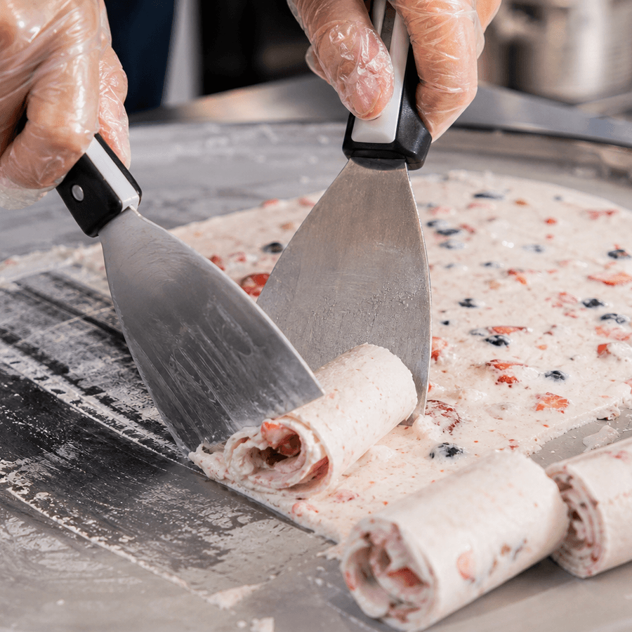 Ice cream being rolled fresh on a frozen cold plate